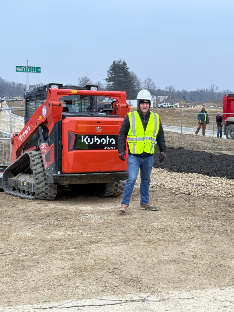 Indiana Topsoil operator on a job site at Marysville Road with a Kubota track loader ready to move aggregate.